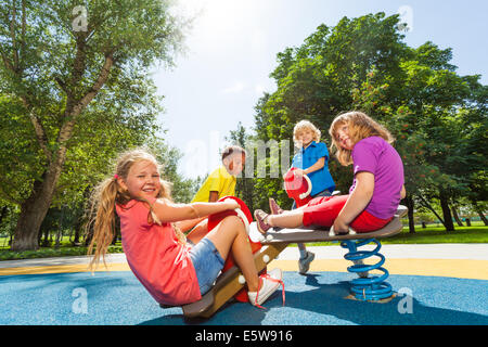 I bambini seduti sul parco giochi giostra con molle Foto Stock