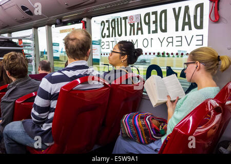 Melbourne Australia,Skybus,autobus aeroportuale,pullman,interno,passeggeri passeggeri passeggeri riders,riders,donne asiatiche,uomini maschi,auricolari,sma Foto Stock