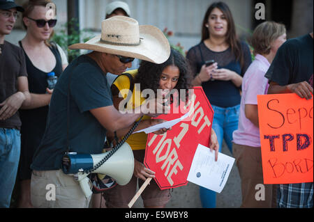 Tucson, Arizona, Stati Uniti. Il 6 agosto, 2014. Circa 50 persone picketed il Tucson il dipartimento di polizia sede a Tucson, in Arizona, oltre la cooperazione di polizia con gli Stati Uniti Pattuglia di Confine. Secondo la polizia i documenti, più di 2700 le chiamate sono state fatte alla polizia di frontiera per i controlli in materia di immigrazione. Pattuglia di Confine hanno risposto 38 volte e ha preso 17 persone in custodia. Credito: Sarà Seberger/ZUMA filo/Alamy Live News Foto Stock