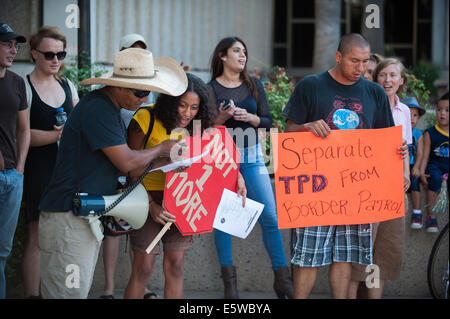 Tucson, Arizona, Stati Uniti. Il 6 agosto, 2014. Circa 50 persone picketed il Tucson il dipartimento di polizia sede a Tucson, in Arizona, oltre la cooperazione di polizia con gli Stati Uniti Pattuglia di Confine. Secondo la polizia i documenti, più di 2700 le chiamate sono state fatte alla polizia di frontiera per i controlli in materia di immigrazione. Pattuglia di Confine hanno risposto 38 volte e ha preso 17 persone in custodia. Credito: Sarà Seberger/ZUMA filo/Alamy Live News Foto Stock