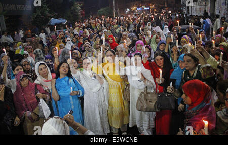 Il pakistan. Il 6 agosto, 2014. Donne attiviste del Pakistan Awami Tehreek (PAT), un seguace di Allama Tahir ul Qadri, che promuove l armonia sociale e religiosa ed è noto anche per la lavorazione su democratica di valori politici in Pakistan, insieme con i membri del Pakistan Lega Musulmana (Q) attesa fiaccolata in memoria delle persone innocenti che hanno perso la vita nel modello di città lo scorso giugno 17, 2014 a Lahore. Vi erano otto (8) persone uccise in uno scontro di cui 2 erano donne. Credito: Rana Sajid Hussain/Pacific Press/Alamy Live News Foto Stock