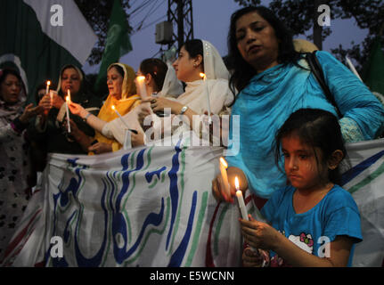 Il pakistan. Il 6 agosto, 2014. Donne attiviste del Pakistan Awami Tehreek (PAT), un seguace di Allama Tahir ul Qadri, che promuove l armonia sociale e religiosa ed è noto anche per la lavorazione su democratica di valori politici in Pakistan, insieme con i membri del Pakistan Lega Musulmana (Q) attesa fiaccolata in memoria delle persone innocenti che hanno perso la vita nel modello di città lo scorso giugno 17, 2014 a Lahore. Vi erano otto (8) persone uccise in uno scontro di cui 2 erano donne. Credito: Rana Sajid Hussain/Pacific Press/Alamy Live News Foto Stock