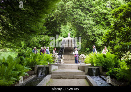 Guida con i visitatori di un verdeggiante giardino paesaggistico con acqua ruscelli a Holker Hall in Cumbria Regno Unito Foto Stock