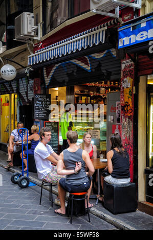 Giovani chat al di fuori di un cafe in luogo centrale, uno di Melbourne alla moda laneways. Corsia; corsie vicolo; Australian coffee shop; Melbourne Australia Foto Stock