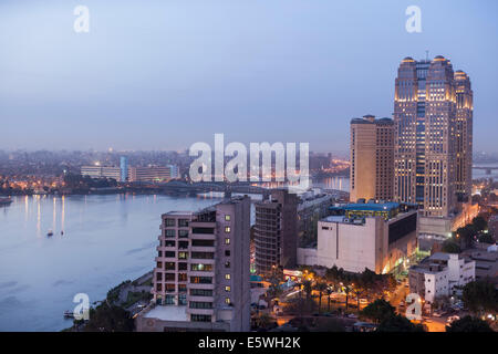 Fiume Nilo al tramonto del Cairo in Egitto - con il Fairmont Nile City Hotel edificio sul lungomare Foto Stock