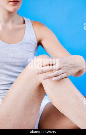 Il dolore al ginocchio di una donna Foto Stock