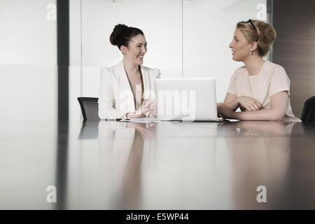 Due giovani imprenditrici avente riunione faccia a faccia in sala conferenze Foto Stock