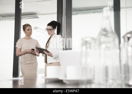 Due giovani imprenditrici avente riuniti nella sala conferenze Foto Stock