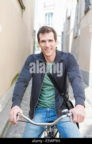 Ritratto di metà uomo adulto sulla bicicletta in una strada di città Foto Stock