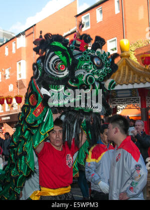 Anno Nuovo Cinese del cavallo inizia a Londra in Chinatown con il tradizionale 'Lion Dance'.La tradizionale cerimonia di 'cai" qing (spiumatura verdi) viene eseguito quando il leone spenna insalata con denaro in buste rosse dangled attaccato dai pali da Foto Stock