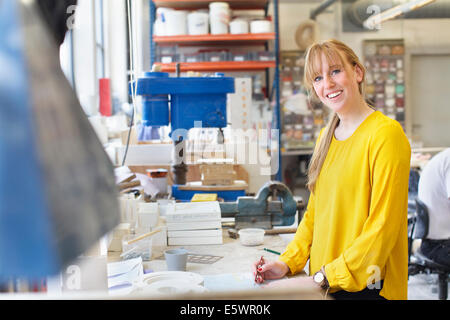 Potter femmina lavorando nel laboratorio di ceramica Foto Stock