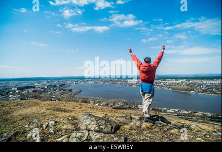 Vista posteriore del giovane femmina escursionista celebrare sulla cima della montagna Foto Stock