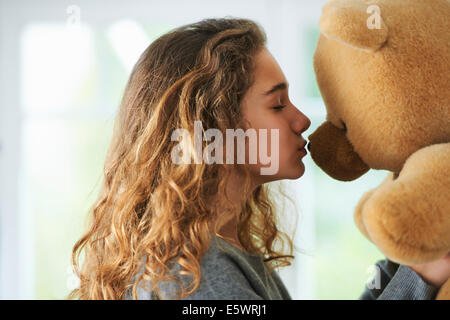 Ritratto di giovane ragazza baciare orsacchiotto Foto Stock