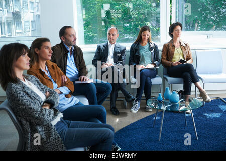 Persone sedute in sala d'attesa Foto Stock