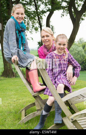 La madre e le figlie seduto sulla sedia in legno, ritratto Foto Stock