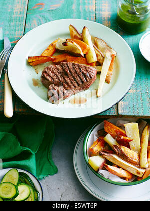 Piastra di Steak salsa verde con patate dolci chips Foto Stock