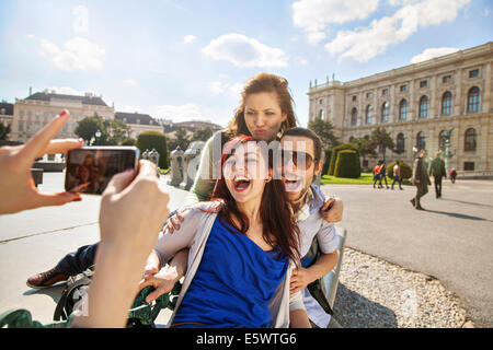 Giovane donna adulta prendendo foto di amici Foto Stock