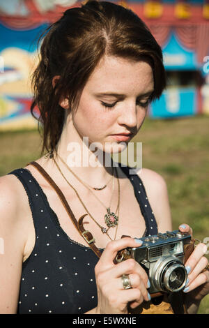 Giovane donna fotografa sulla fotocamera reflex al luna park