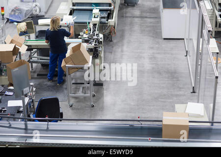 Donna matura lavorando in imballaggi di carta la fabbrica Foto Stock