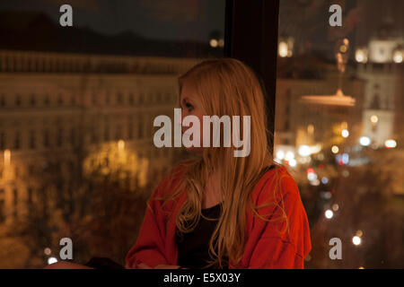 Giovane donna godendo di vista dalla camera dell'albergo, Vienna, Austria Foto Stock