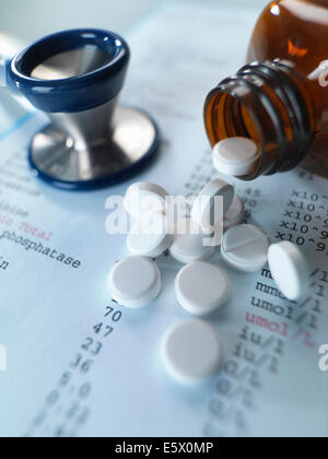 Lo stetoscopio e antidolorifici versare su risultati di esami medici Foto Stock