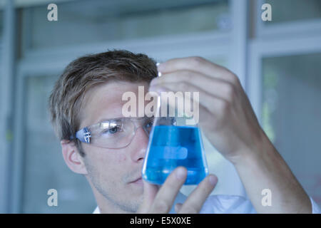 In prossimità di uno scienziato maschio mantenendo la beuta di Erlenmeyer in laboratorio Foto Stock
