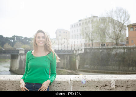 Giovane donna appoggiata contro la parete, l'Isola Tiberina, Roma, Italia Foto Stock