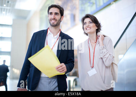 Imprenditore e imprenditrice con la documentazione in conference center atrium Foto Stock