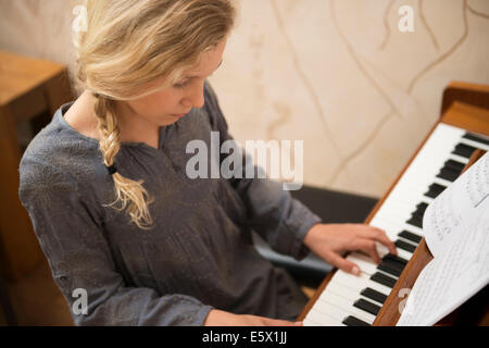 Ragazza suonare il pianoforte nella sala da pranzo Foto Stock