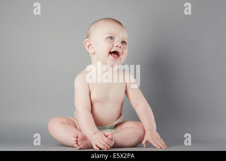 Ritratto in studio di curioso bimbo seduto Foto Stock