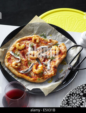 Fette di pizza a base di pesce bianco con acciughe, gamberi, olio d'oliva e guarnire aneto Foto Stock