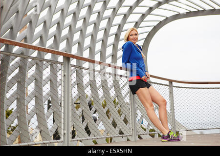 Donna in appoggio contro la riga, Tongva Park, Santa Monica, California, Stati Uniti d'America Foto Stock