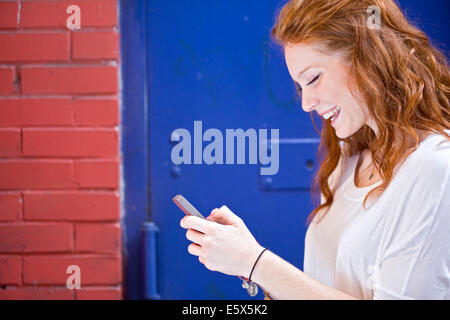 Ritratto di giovane donna utilizzando il telefono cellulare Foto Stock