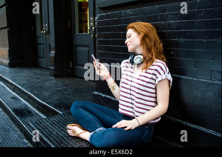 Ritratto di giovane donna utilizzando il telefono cellulare Foto Stock