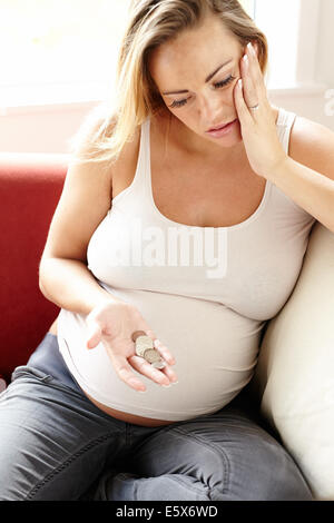 Donna incinta con preoccupazioni di denaro Foto Stock