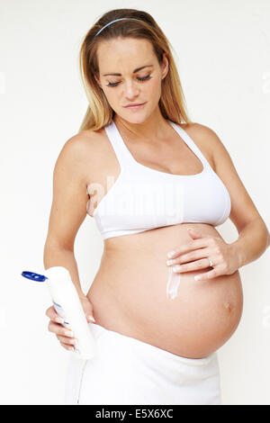Donna incinta e idratante Foto Stock