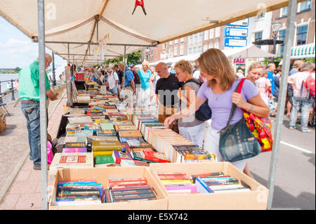 La gente si guarda intorno nella seconda mano prenota bancarelle. Prenota stand pieni di libri e la promenade affollate di persone per lo shopping. Foto Stock