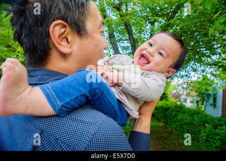 Metà adulto padre giocando con il bambino figlio in giardino Foto Stock