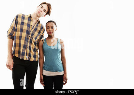 Ritratto in studio che mostra altezza contrastanti di coppia giovane Foto Stock