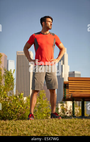 Giovane maschio runner prendendo una pausa in posizione di parcheggio Foto Stock