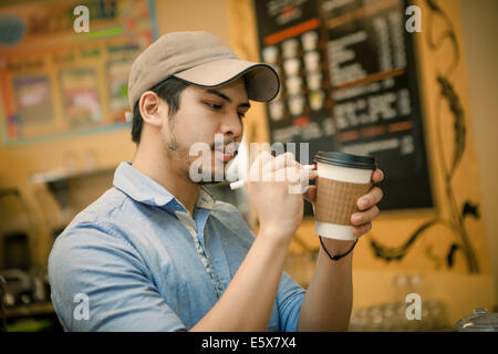 Barista iscritto sulla tazza monouso in cafe Foto Stock