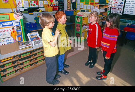 Due ragazze e due ragazzi parlare in Aula Foto Stock