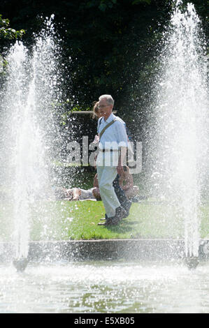 Cardiff, Glamorgan, Wales, Regno Unito. Il 7 agosto 2014. Le persone a rilassarsi in un giorno caldo da raffreddare una fontana di acqua a Cardiff. Credito: Graham M. Lawrence/Alamy Live News. Foto Stock