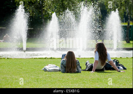 Cardiff, Glamorgan, Wales, Regno Unito. Il 7 agosto 2014. Le persone a rilassarsi in un giorno caldo da raffreddare una fontana di acqua a Cardiff. Credito: Graham M. Lawrence/Alamy Live News. Foto Stock
