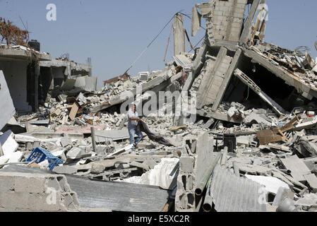 Khan Younis, Striscia di Gaza, Territori palestinesi. Il 7 agosto, 2014. Un uomo palestinese cerca nel suo distrutto casa che è stato colpito in un attacco aereo israeliano su Abasan, a est del sud della striscia di Gaza città di Khan Yunis e vicino al confine con Israele il 7 agosto 2014. Numerose persone sono state uccise in attacco Credito: Abed Rahim Khatib/immagini APA/ZUMA filo/Alamy Live News Foto Stock