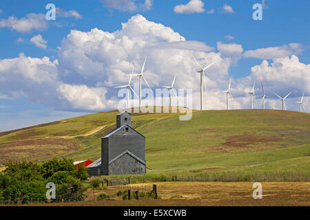Una fattoria e grano silo oscurato dalle turbine eoliche in remoto Impero Palouse regione, di allevamento e di produzione del frumento regione orientale di Washington. Foto Stock