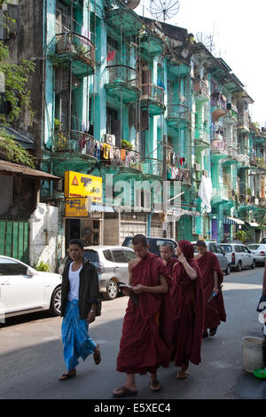 I monaci a piedi giù per una strada nel centro di Yangon, Myanamar (Birmania). Foto Stock