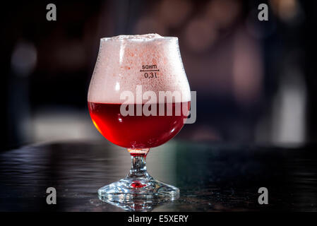 Bicchiere di birra di ciliegio è sul tavolo del bar Foto Stock