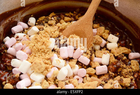 La combinazione di cioccolato fuso con mini marshmallows e biscotti sbriciolati in una strada rocciosa ricetta Foto Stock