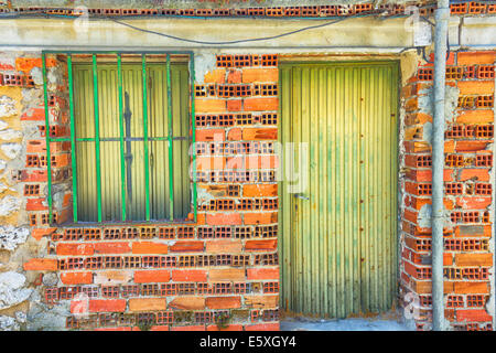 Sfondo mattone piccola casa in costruzione con porta e finestra Foto Stock